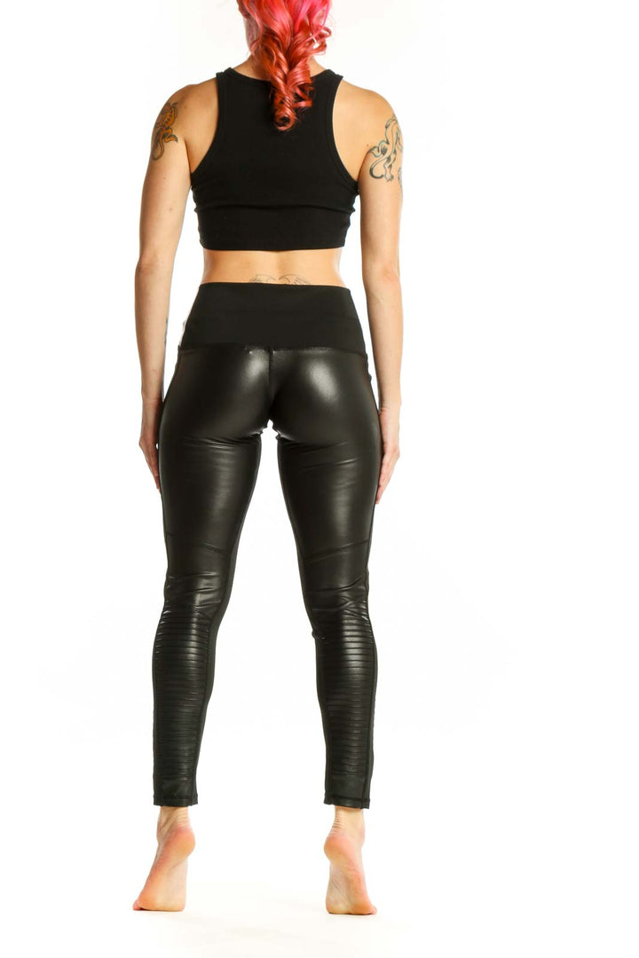 Black ruched faux leather leggings back view, showing ruched texture and cropped ankle length