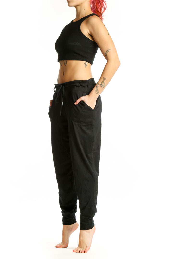 LOLE black jogger pants with drawstring waist and side pockets, front view on model