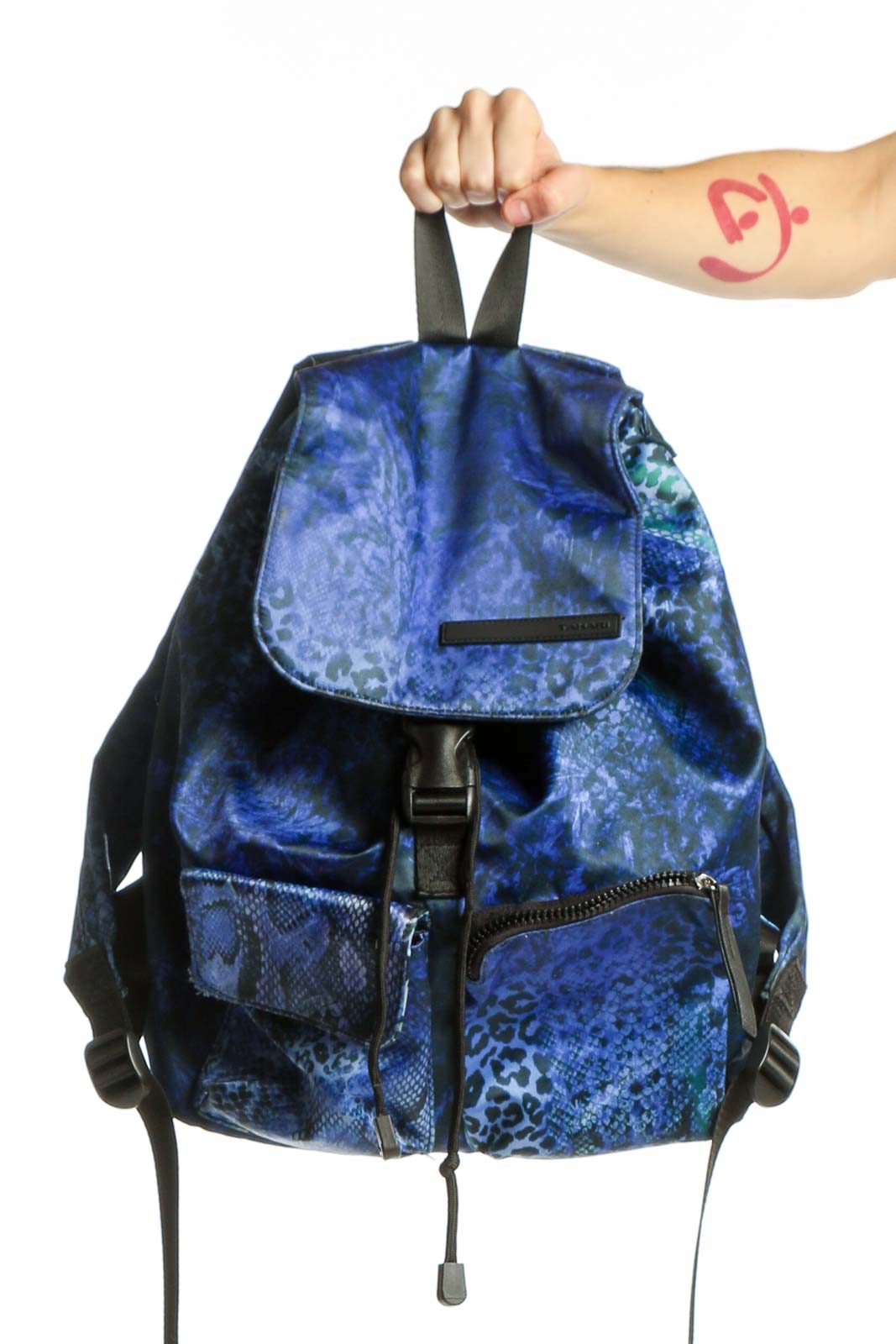 Blue velvet backpack with snake print design and black straps held by hand