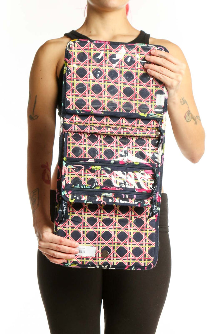 Black floral quilted Vera Bradley clutch worn as crossbody accessory with snap closure detail