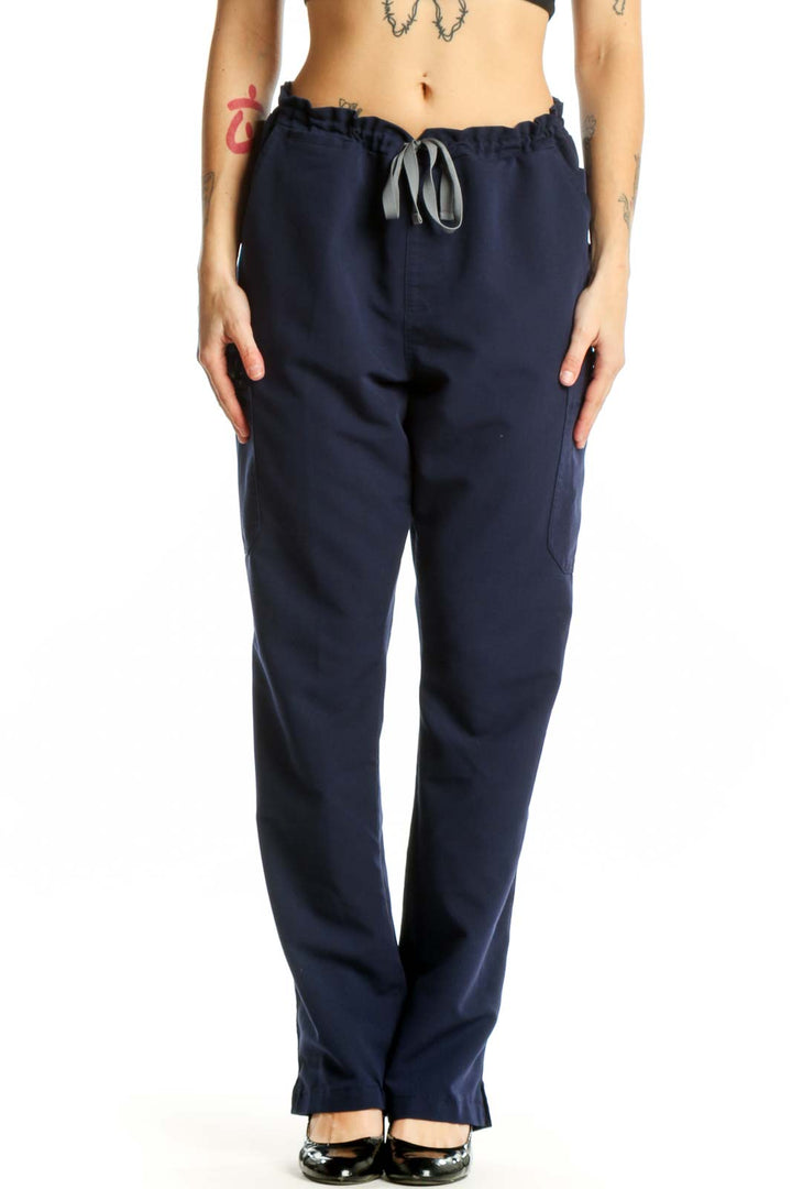 Navy drawstring scrub pants with side pockets, front view on model