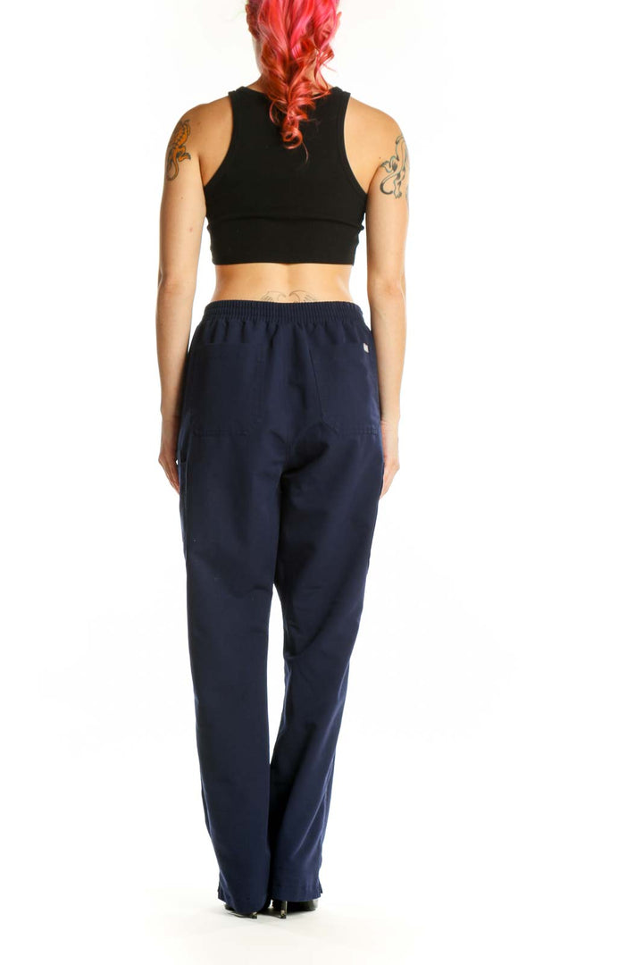Navy drawstring scrub pants with side pockets, back view on model