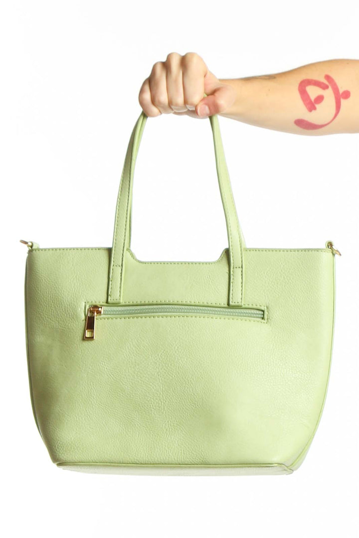 SilkRoll mint green leather satchel tote bag with dual handles and front zippered pocket, held by hand