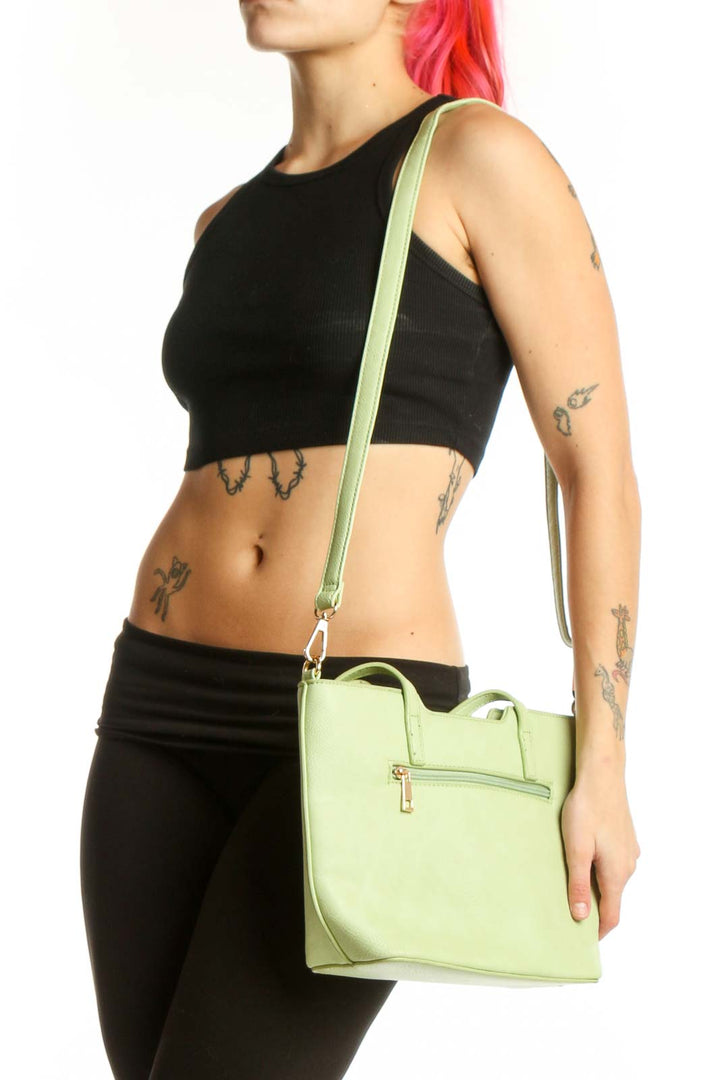 SilkRoll mint green leather satchel tote bag with dual handles and front zippered pocket, held by hand