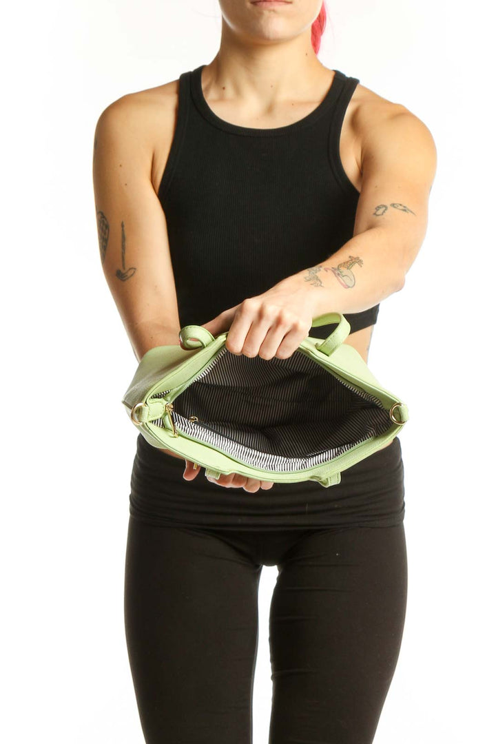 SilkRoll mint green leather satchel worn as crossbody bag, showing side profile and structured silhouette