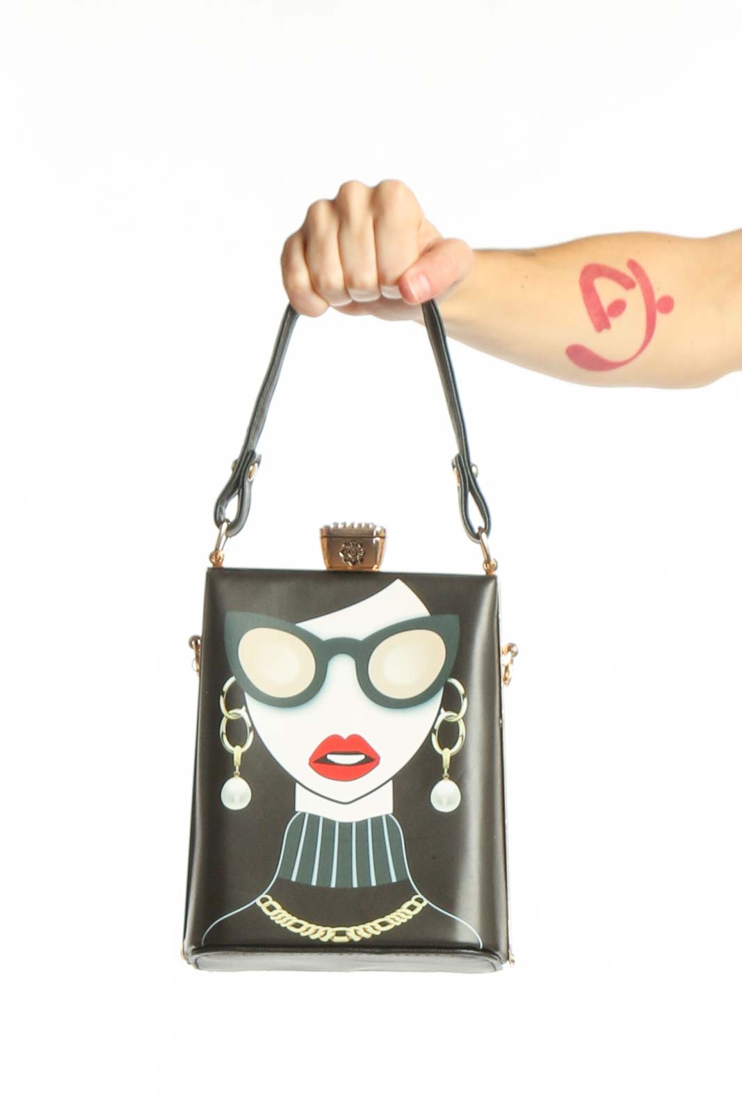 Black SilkRoll crossbody clutch with illustrated fashion portrait featuring woman in oversized sunglasses, red lips, and gold chain details