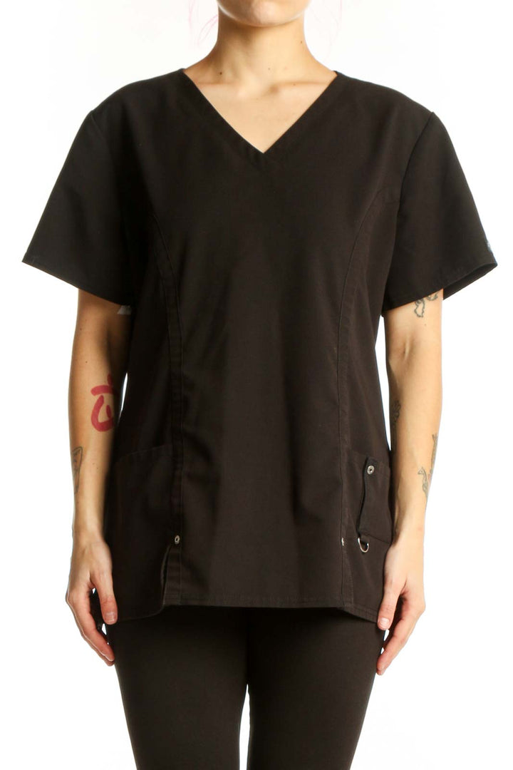 Black V-Neck Medical Scrub Top by Dickies with side pockets and drawstring details, front view on model