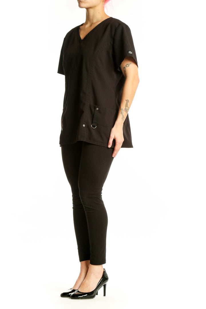 Black V-Neck Medical Scrub Top by Dickies with side pockets and drawstring details, front view on model