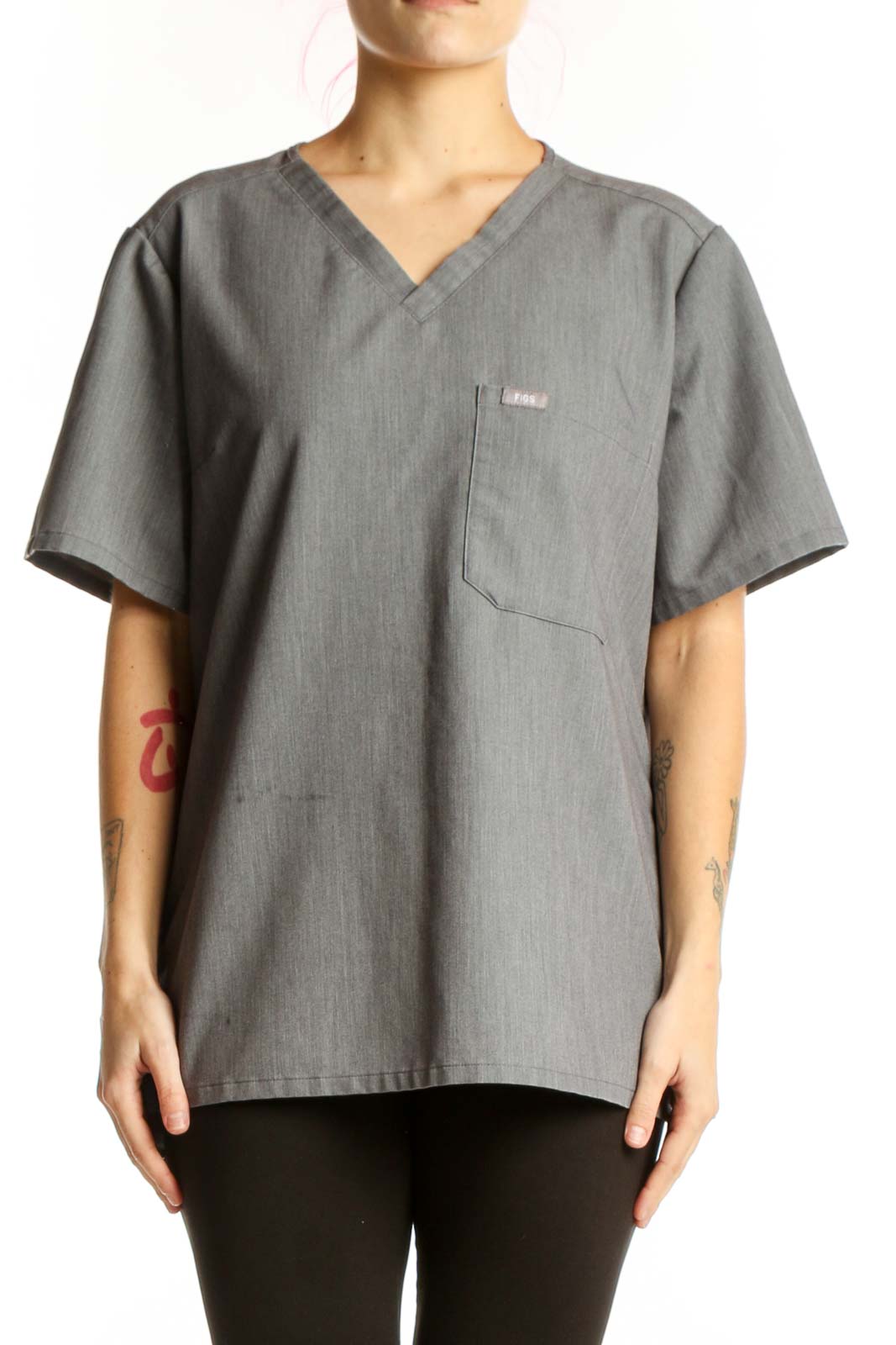 Gray V-neck FIGS medical scrub top with chest pocket, front view on model