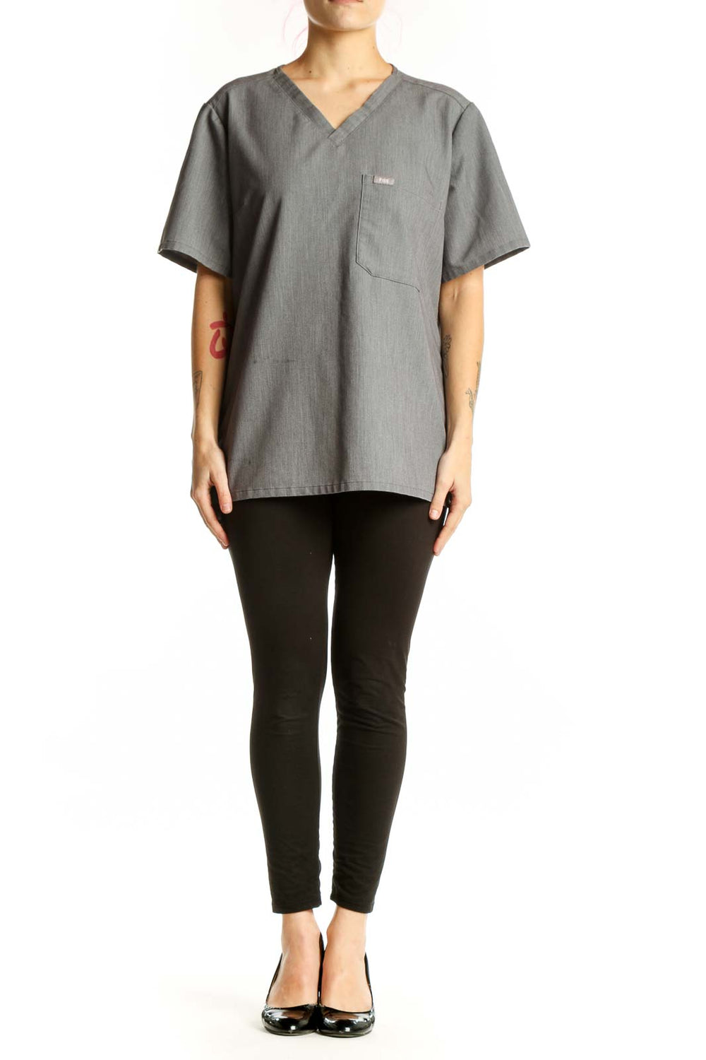 Gray V-neck FIGS medical scrub top with chest pocket, front view on model