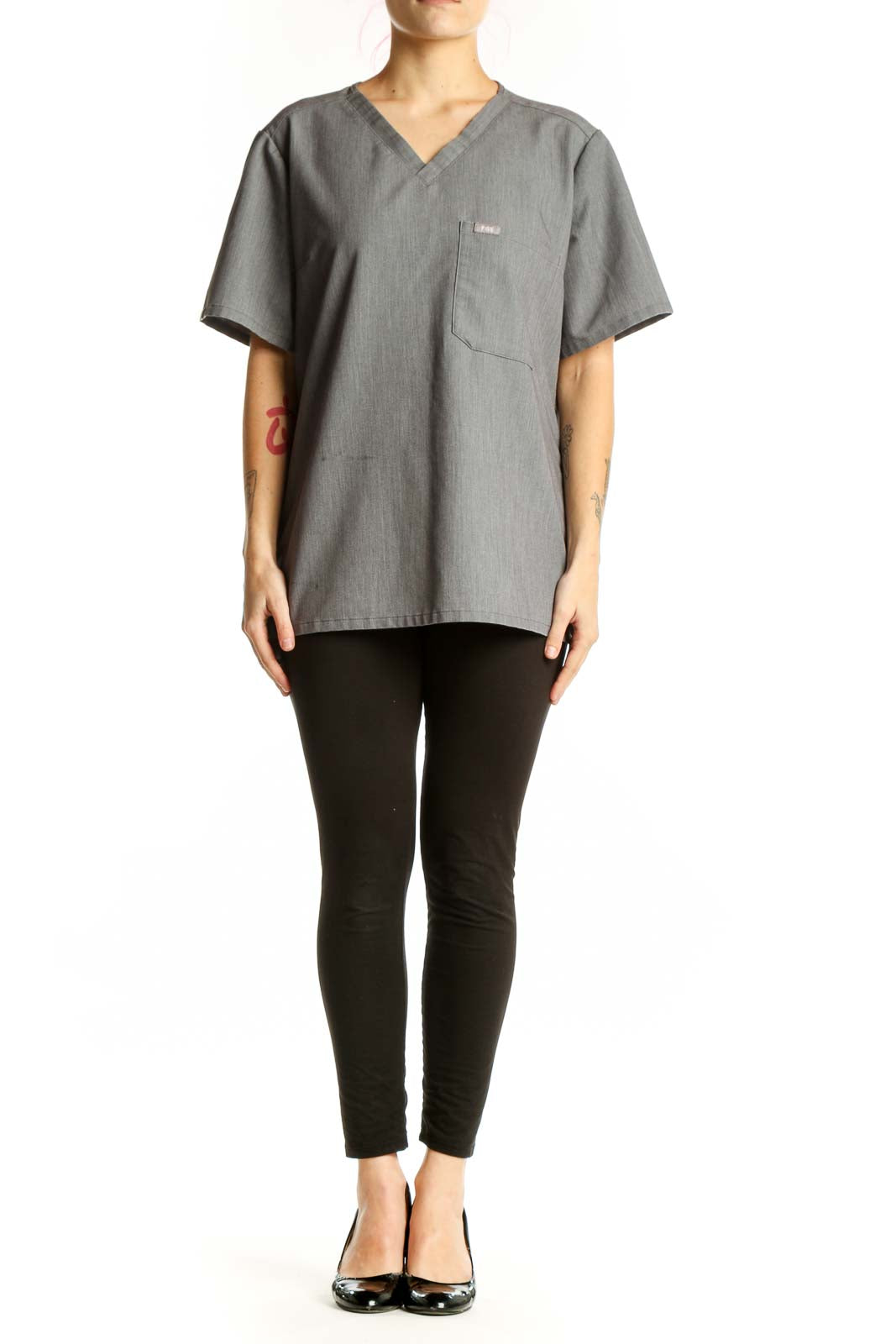 Gray V-neck FIGS medical scrub top with chest pocket, front view on model