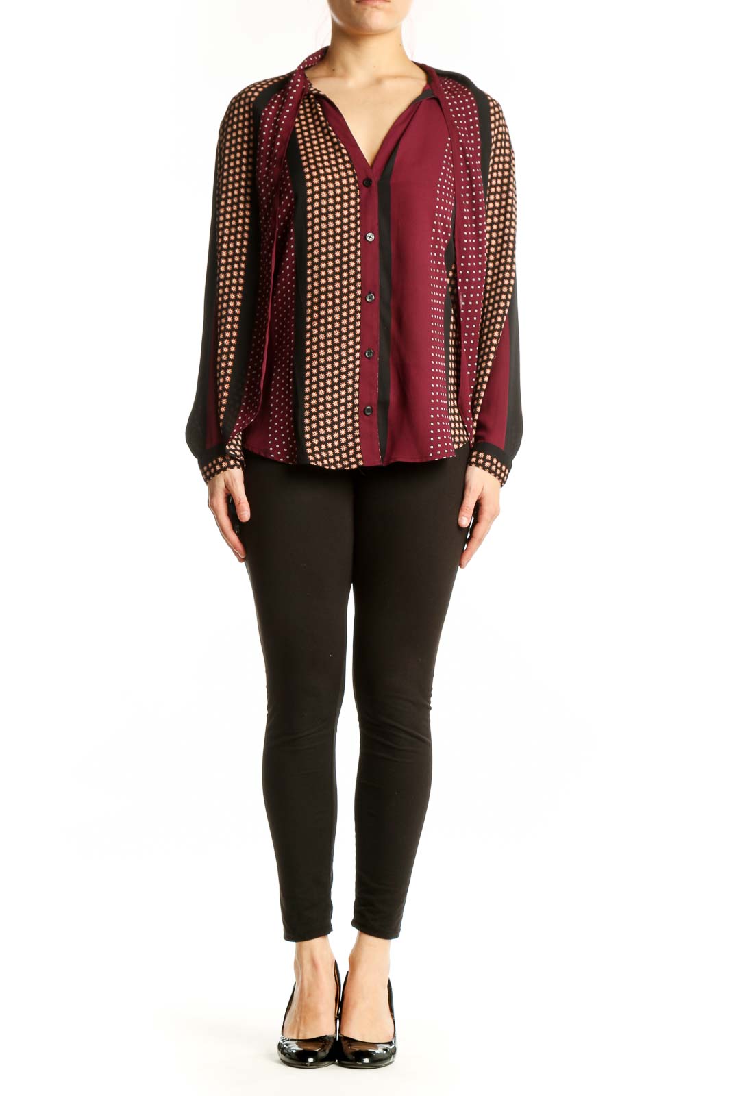 Burgundy polka dot button-up blouse with cream and gold patterned sleeves, front view on model