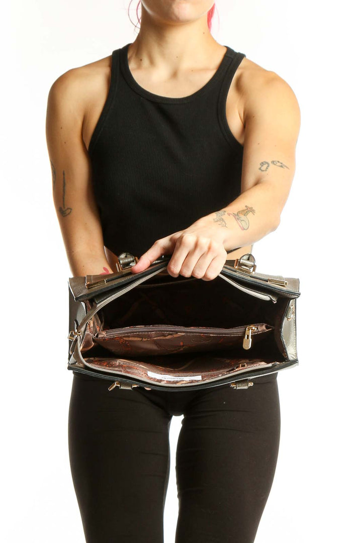 Back view of silver metallic tote bag with front zippered pocket and gold accents