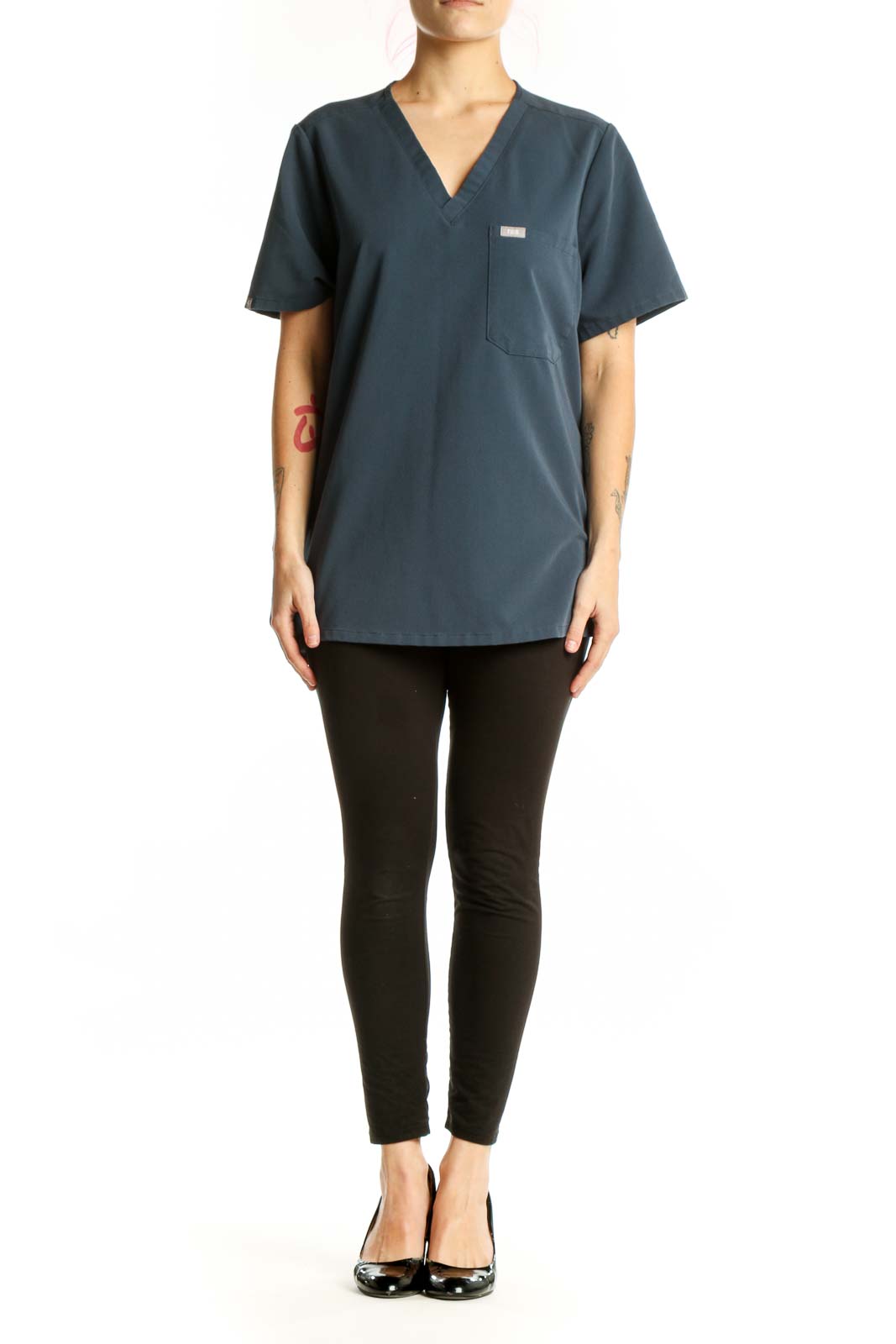 Navy V-neck FIGS medical scrub top with chest pocket, front view on model