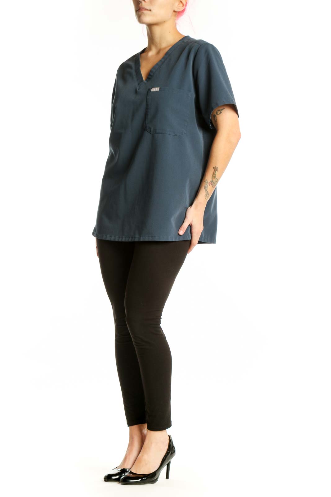 Navy V-neck FIGS medical scrub top with chest pocket, front view on model