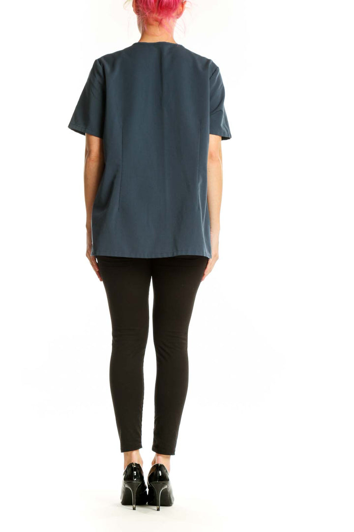 Navy V-neck FIGS medical scrub top, back view on model