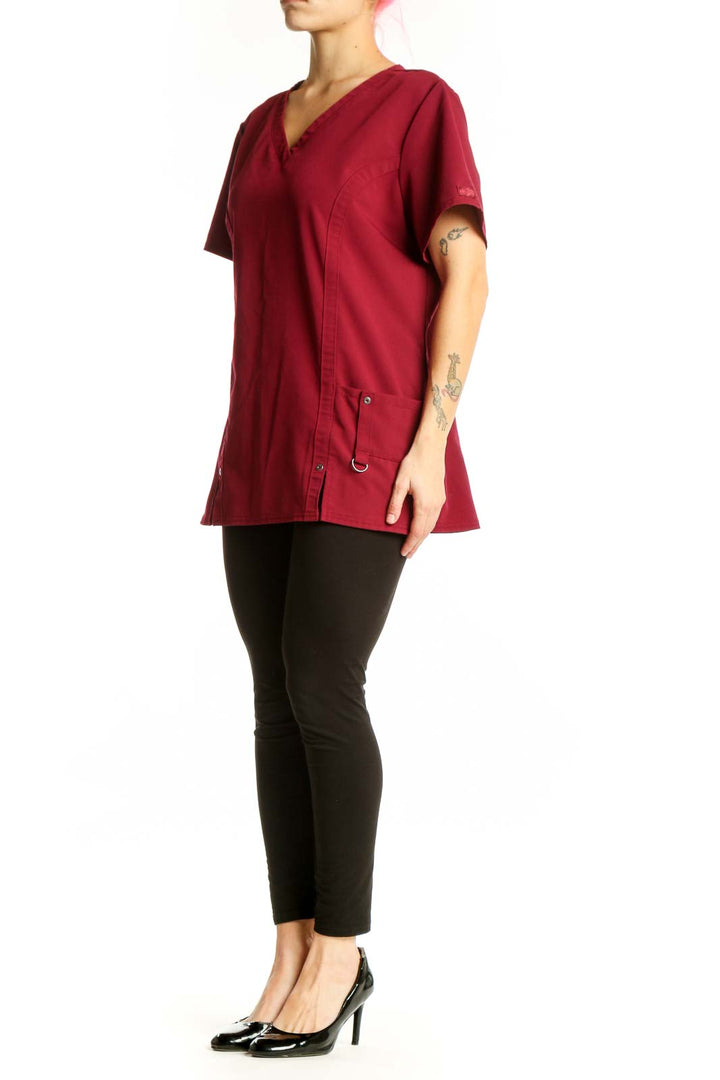 Burgundy v-neck short sleeve top with side pockets and button details, front view on model