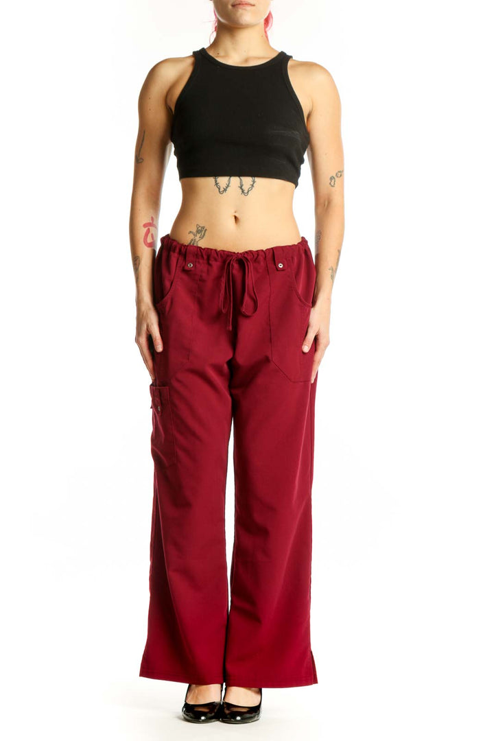Front view of burgundy Dickies cargo pants with drawstring waist and functional side pockets on model