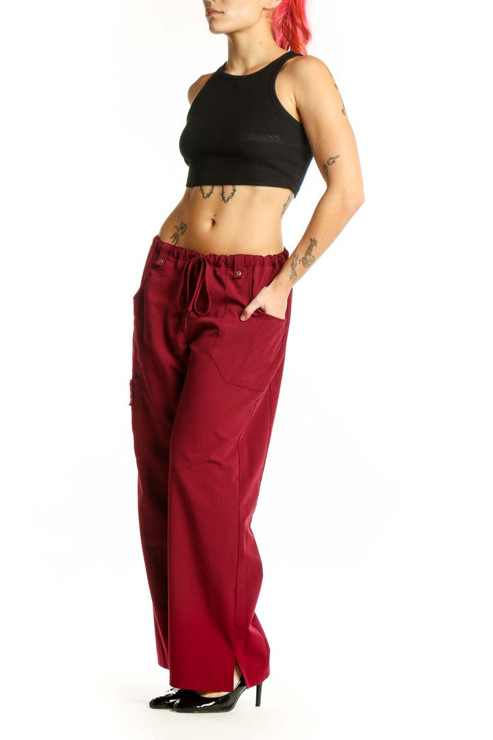 Front view of burgundy Dickies cargo pants with drawstring waist and functional side pockets on model