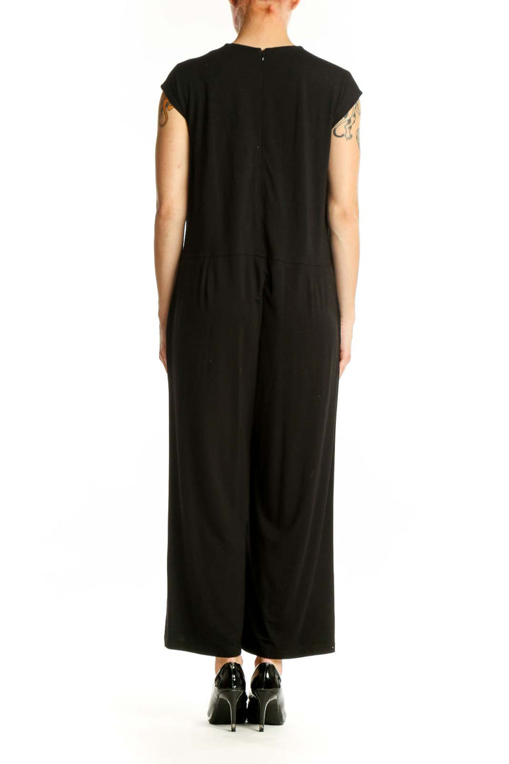 Black Eileen Fisher jumpsuit back view displaying relaxed fit, side pockets, and elegant cropped wide-leg silhouette