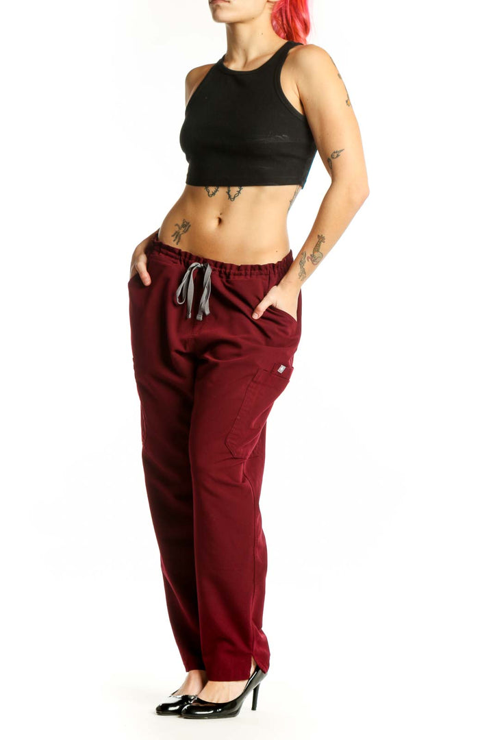 Front view of burgundy drawstring cargo pants with side pockets and elastic waistband