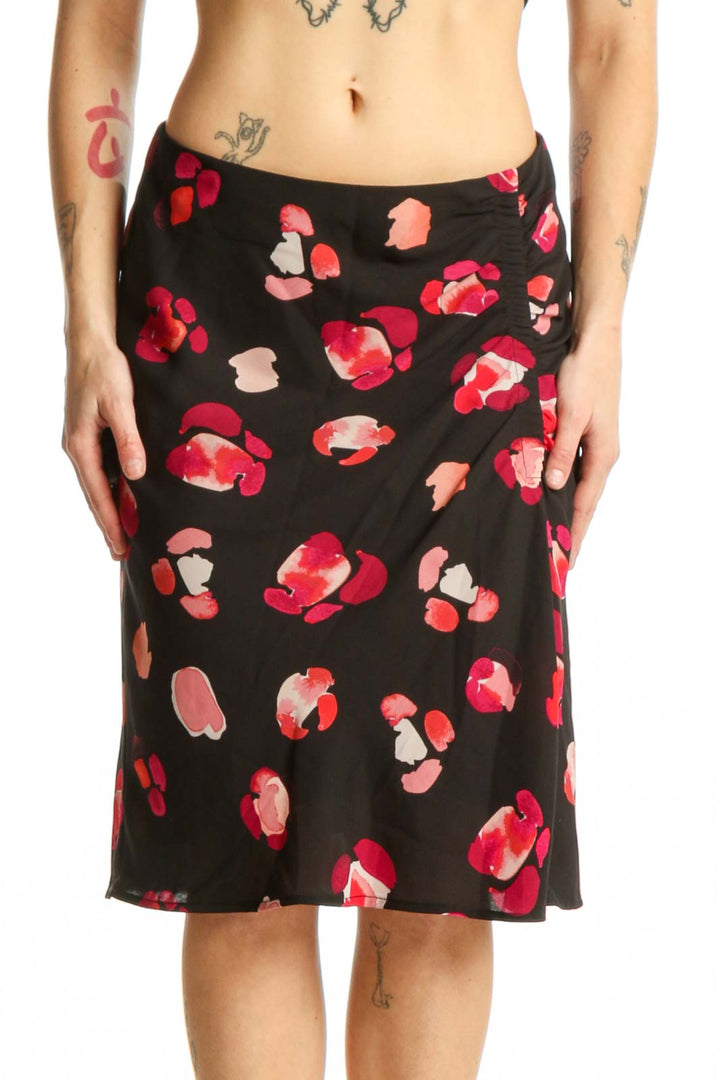Black knee-length skirt with red and pink floral print, front view on model