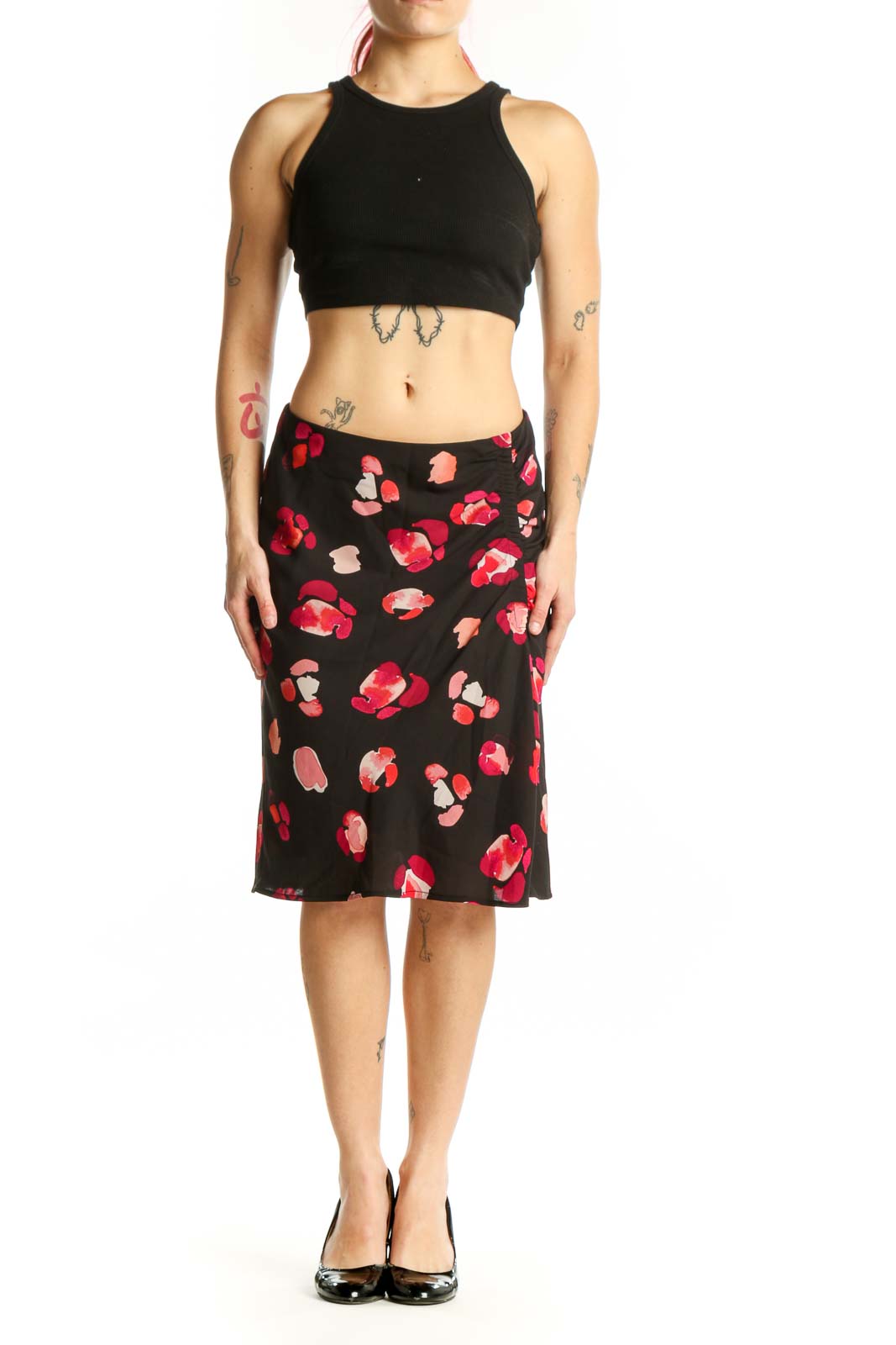 Black knee-length skirt with red and pink floral print, front view on model