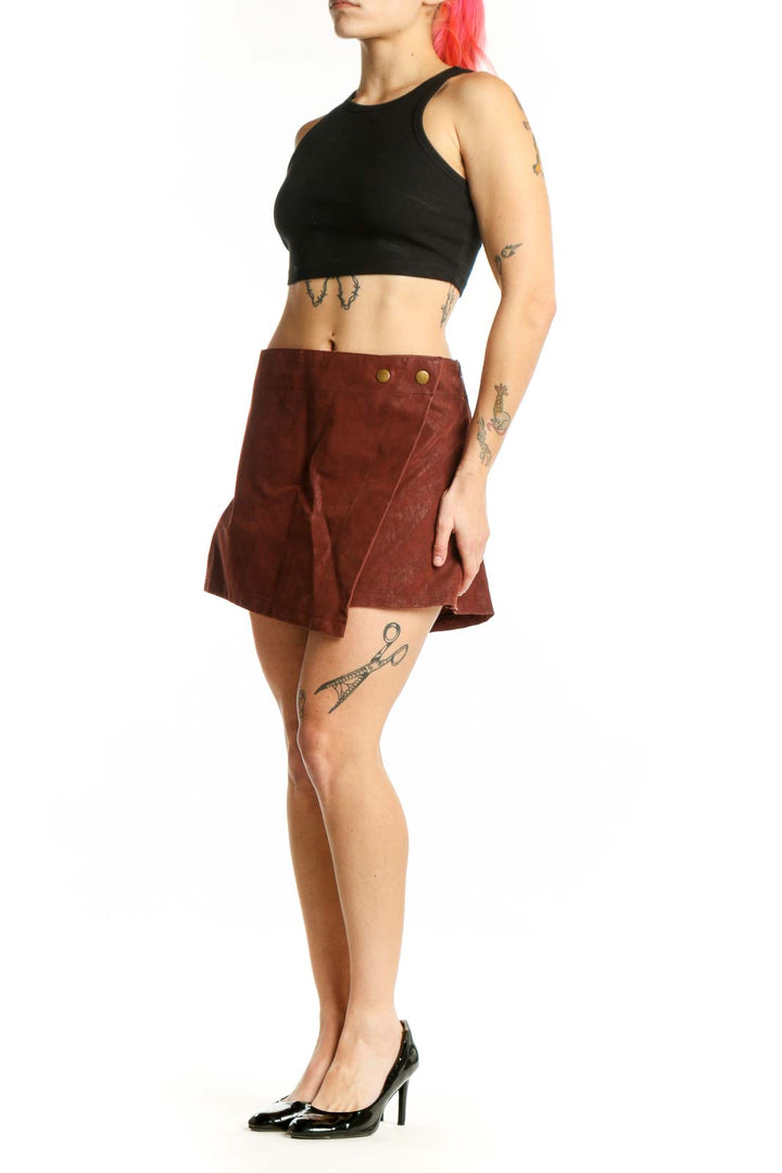 Burgundy suede mini shorts with metallic button accents and asymmetrical A-line hem, front view