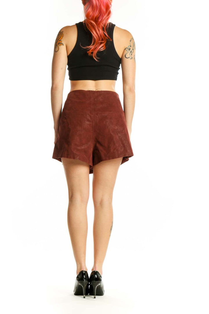 Burgundy suede mini shorts with metallic button accents, side view showing asymmetrical silhouette