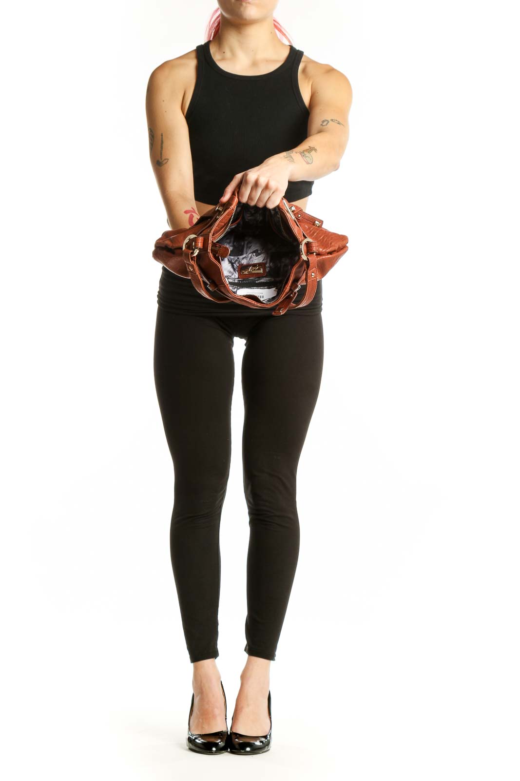 Back view of cognac leather shoulder bag worn as shoulder bag with adjustable strap