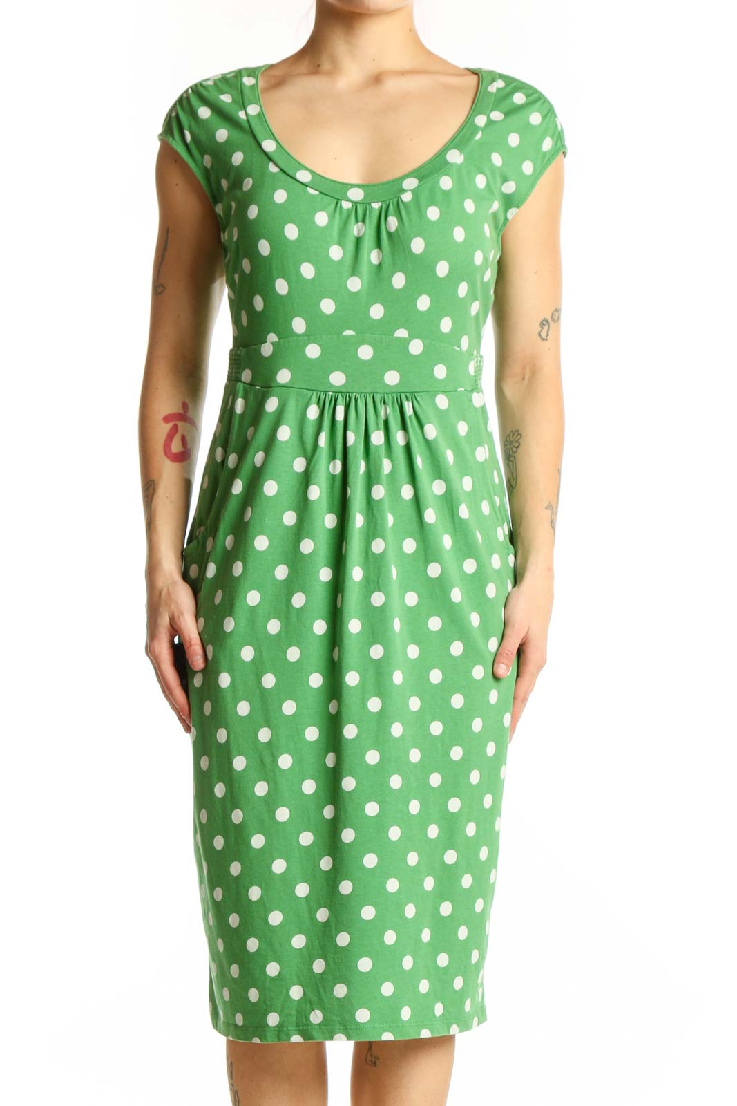 Green polka dot midi dress with white dots, scoop neckline, and cap sleeves on model