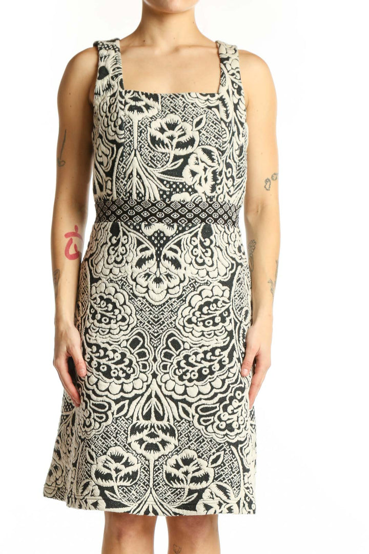 Front view of cream and black ornamental print sleeveless dress with square neckline and A-line silhouette