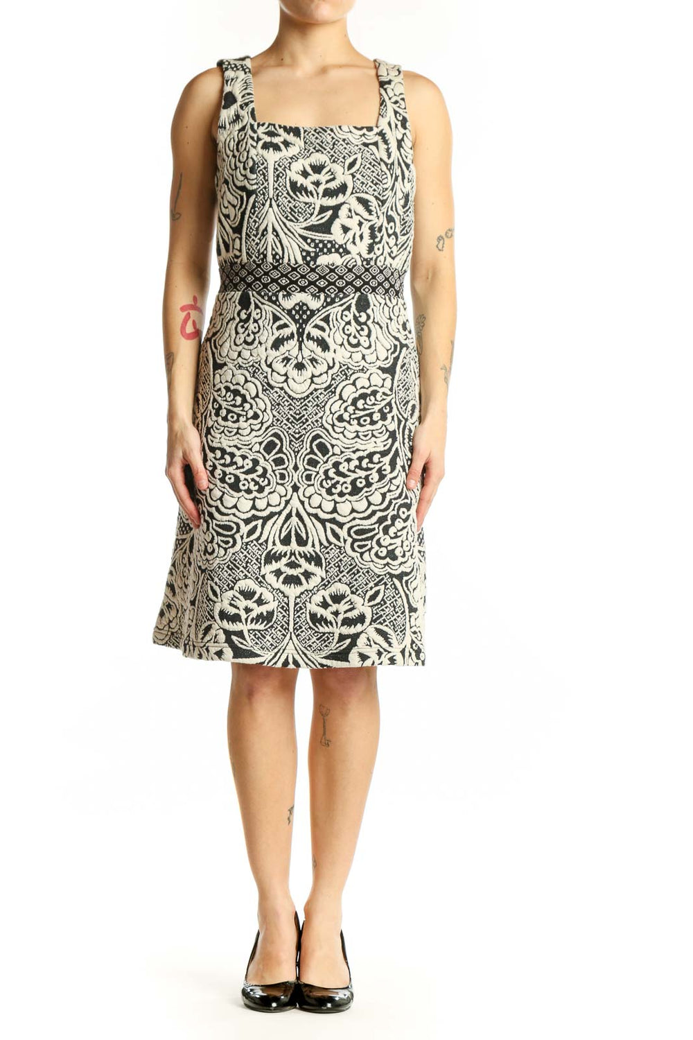 Front view of cream and black ornamental print sleeveless dress with square neckline and A-line silhouette