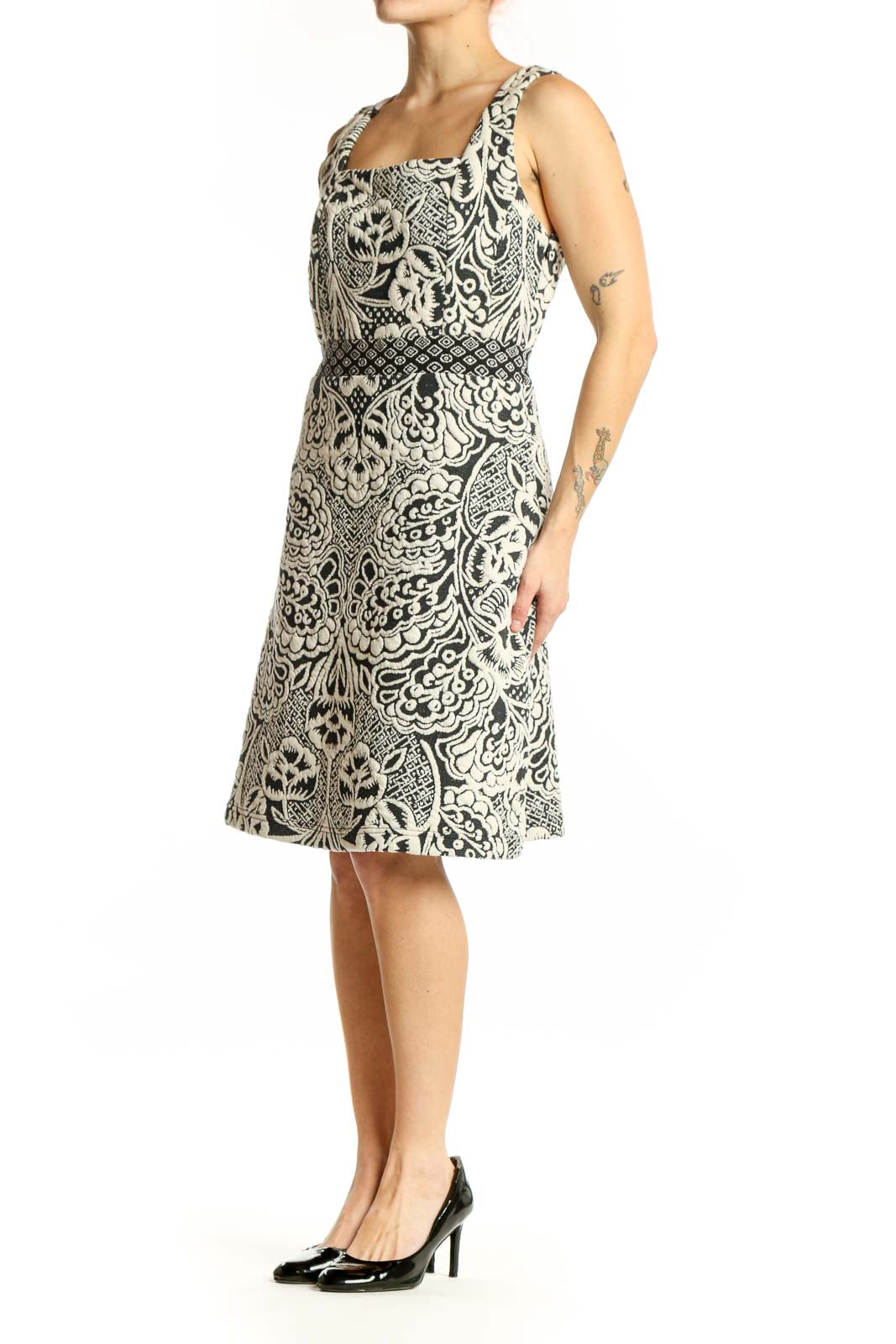 Front view of cream and black ornamental print sleeveless dress with square neckline and A-line silhouette