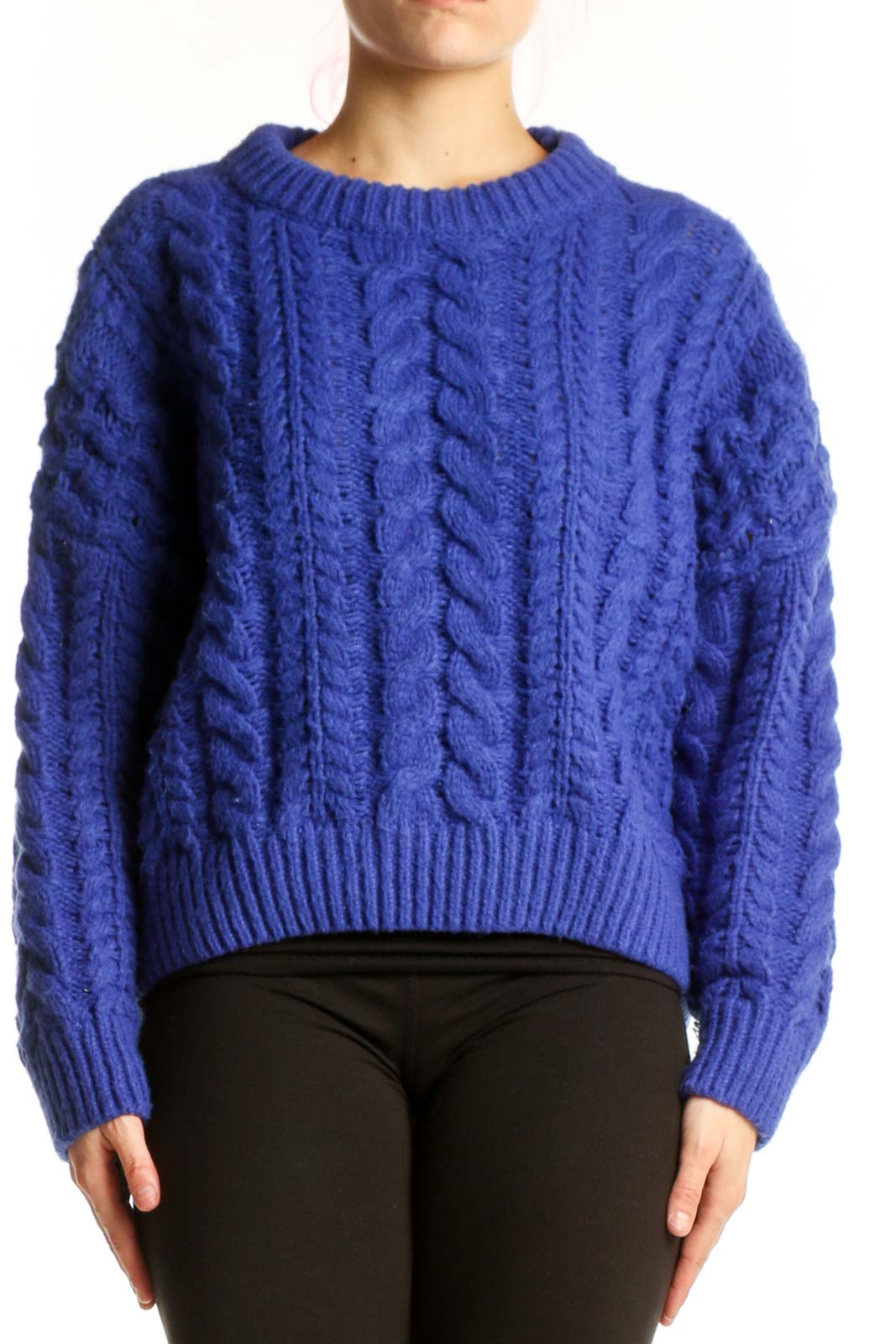 Blue cable knit pullover sweater with crew neckline and cropped length, worn with black pants
