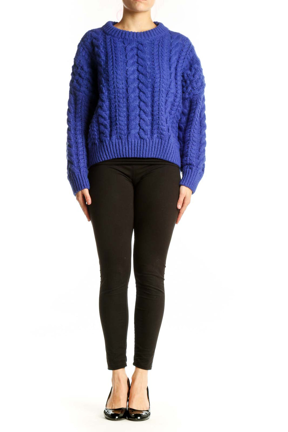 Blue cable knit pullover sweater with crew neckline and cropped length, worn with black pants