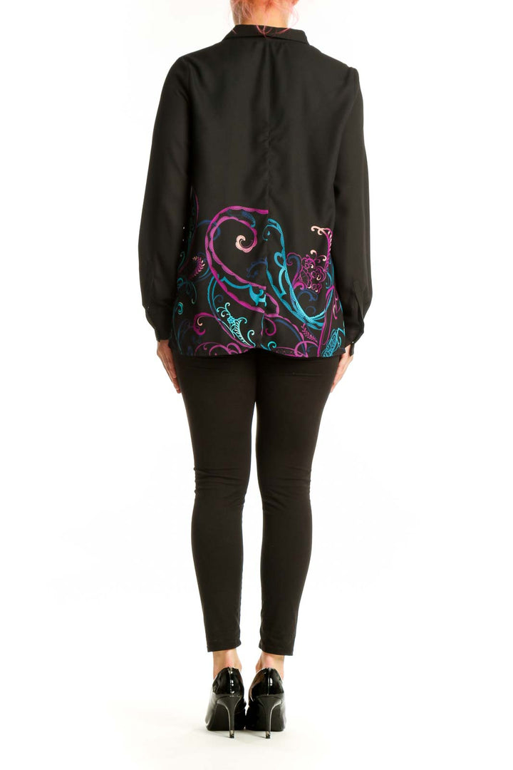 Back view of black embroidered floral blouse showing ornate scrollwork design