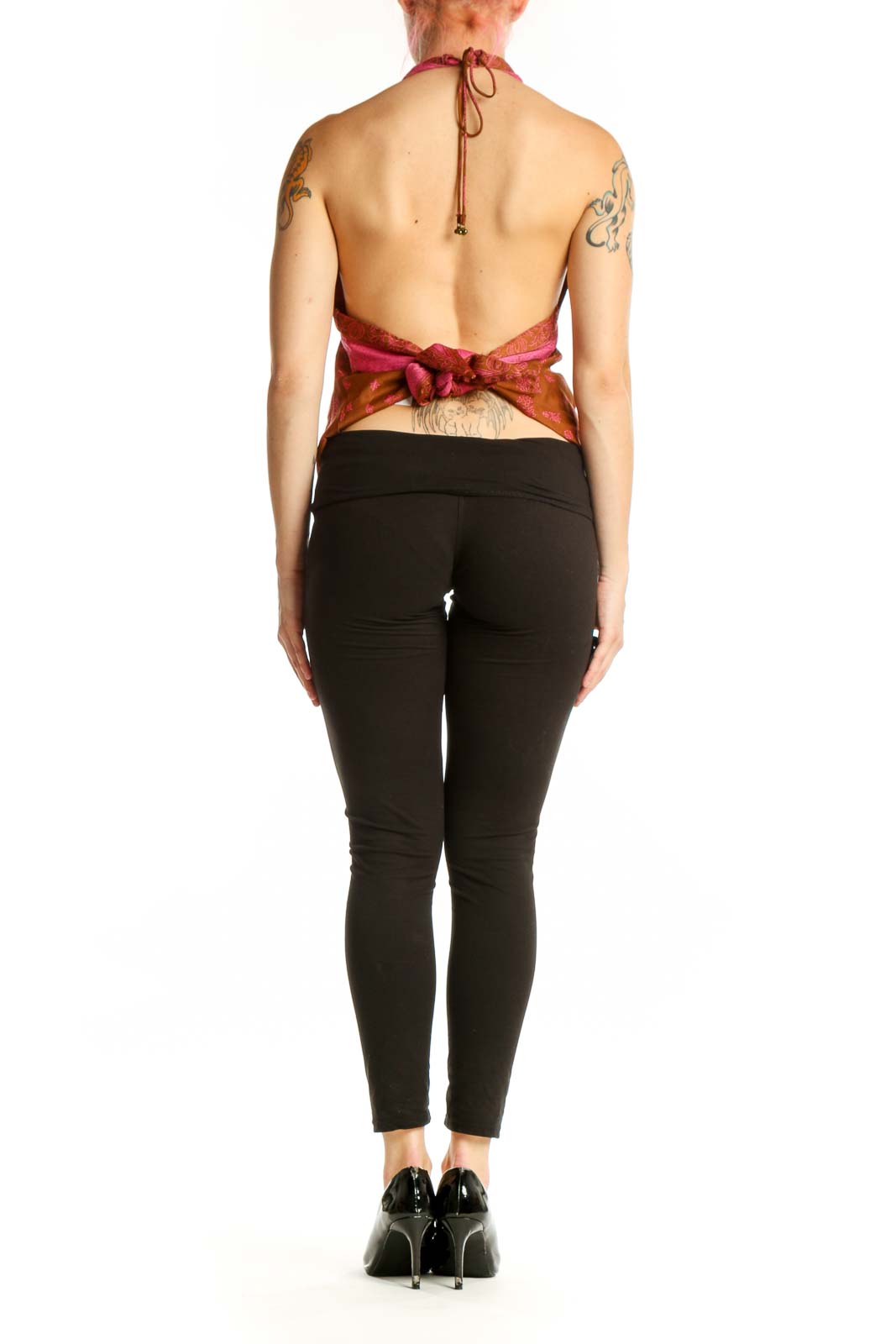 Orange floral halter neck tank top with pink straps, back view on model wearing black pants