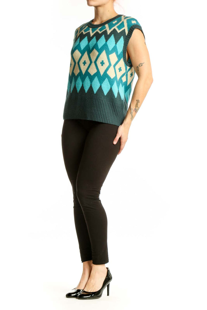 Tyler Boe teal geometric diamond knit vest with cream and charcoal colorblock pattern, front view on model