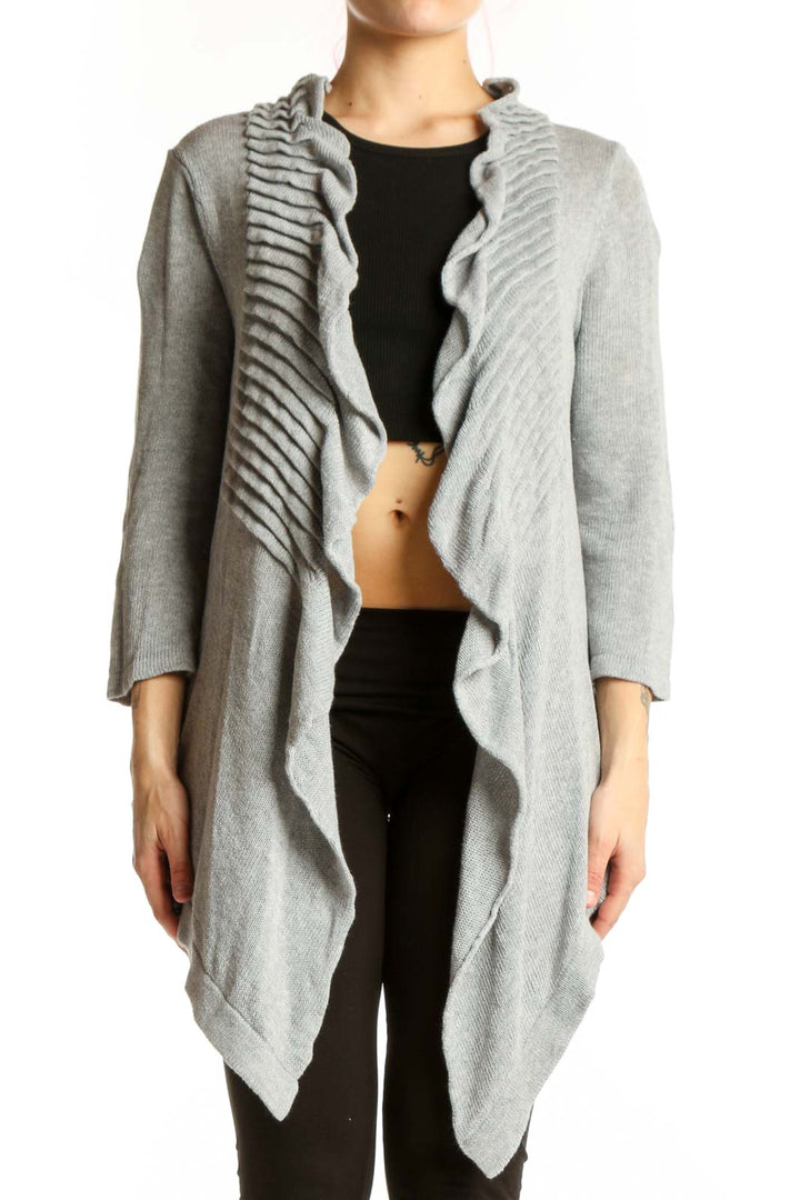 Gray cotton cardigan with ruffled front detailing and open front design, worn over black top