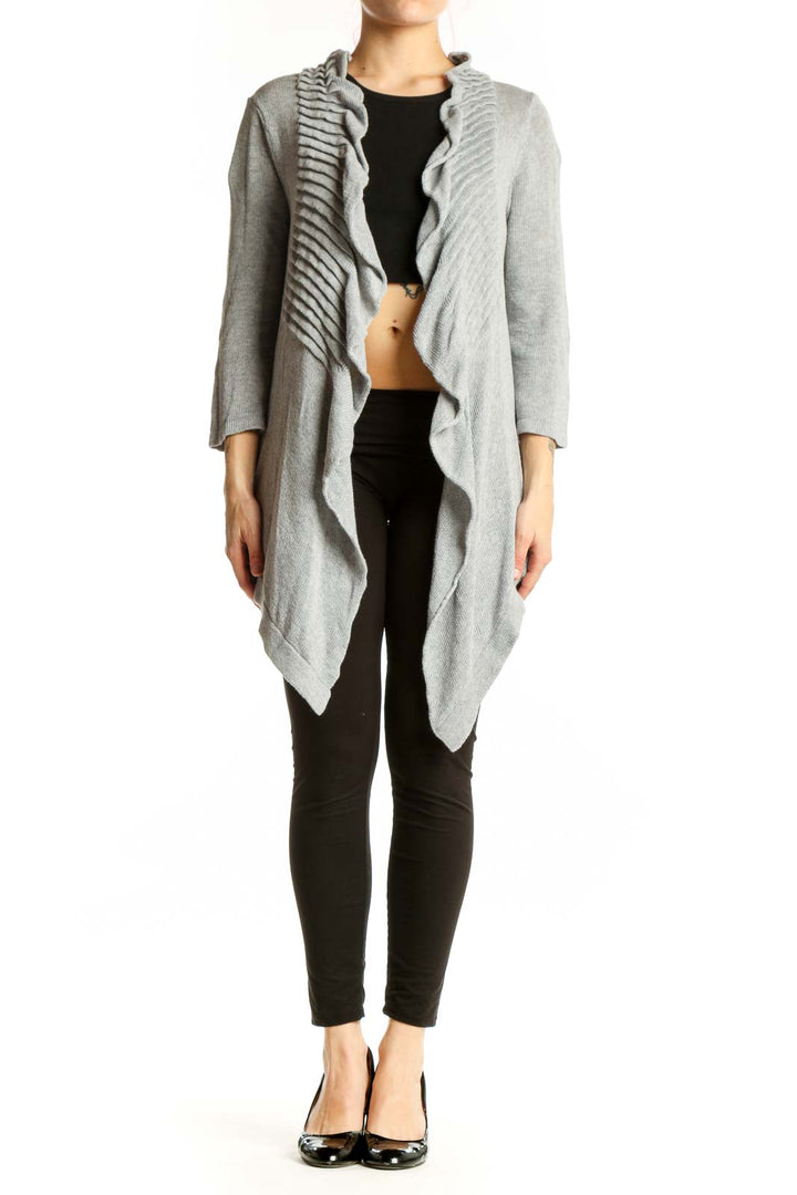 Gray cotton cardigan with ruffled front detailing and open front design, worn over black top