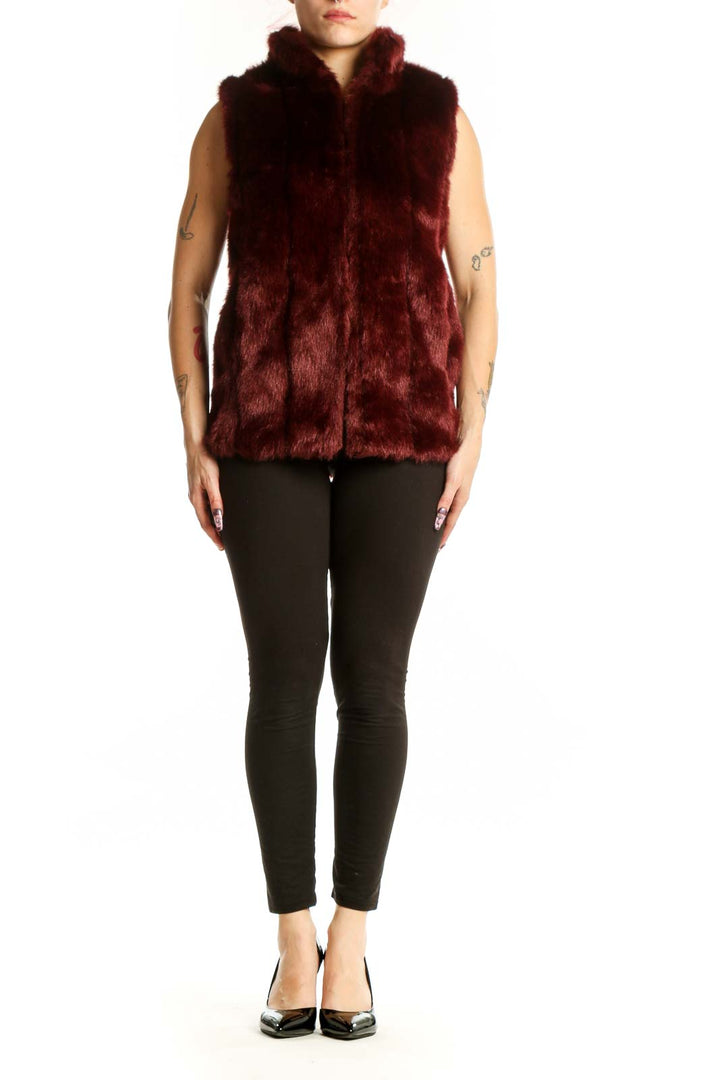 Burgundy faux fur sleeveless vest with front zip closure, worn as a layering piece over black pants