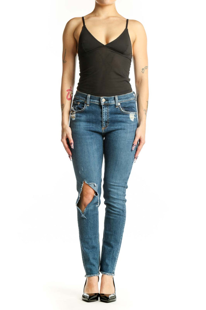 Front view of blue distressed skinny jeans with ripped thigh detailing and cropped ankle length