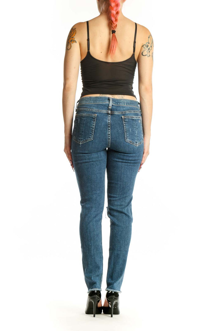 Back view of blue distressed skinny jeans showing classic five-pocket styling and fitted silhouette