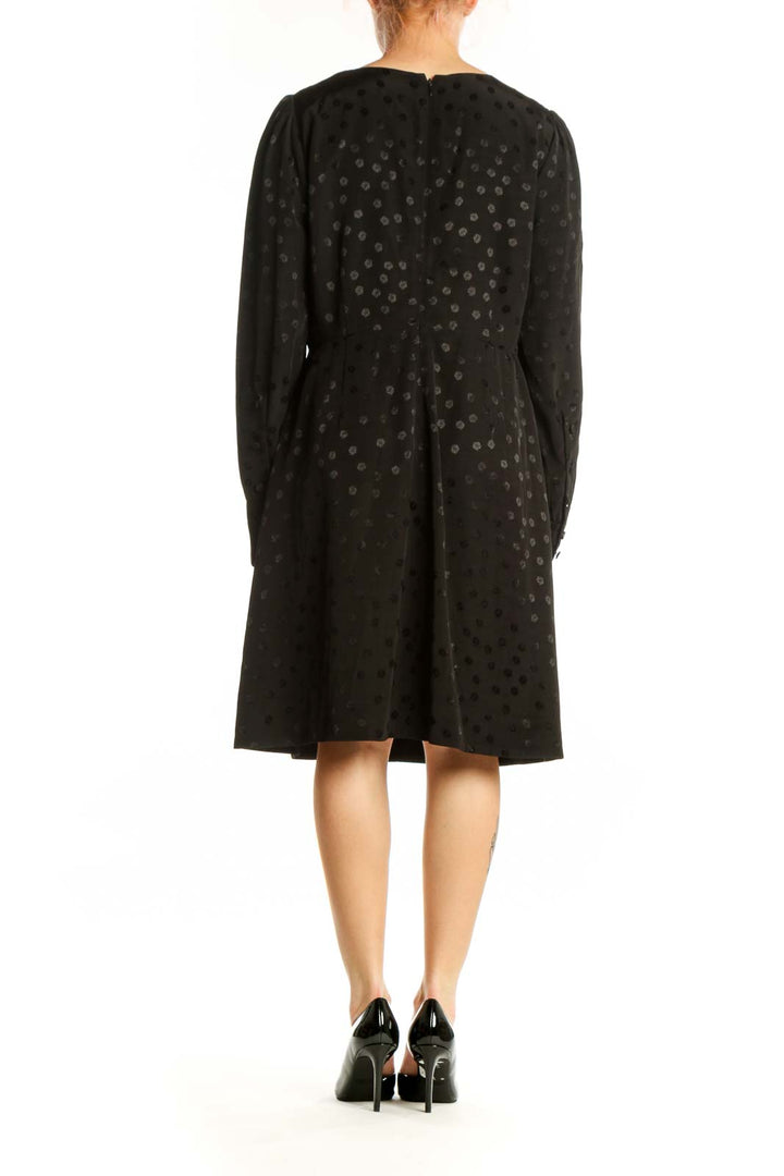 Black polka dot long sleeve dress with gathered cuffs, back view