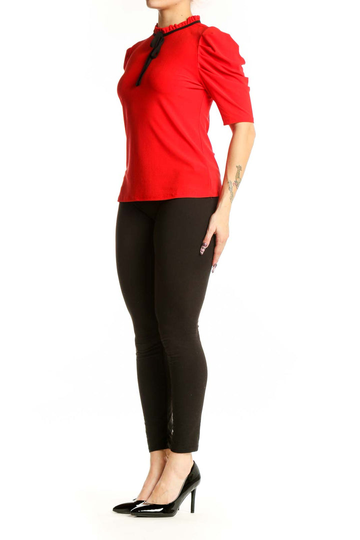 Red puff sleeve top with ruched neckline and black tie detail, front view