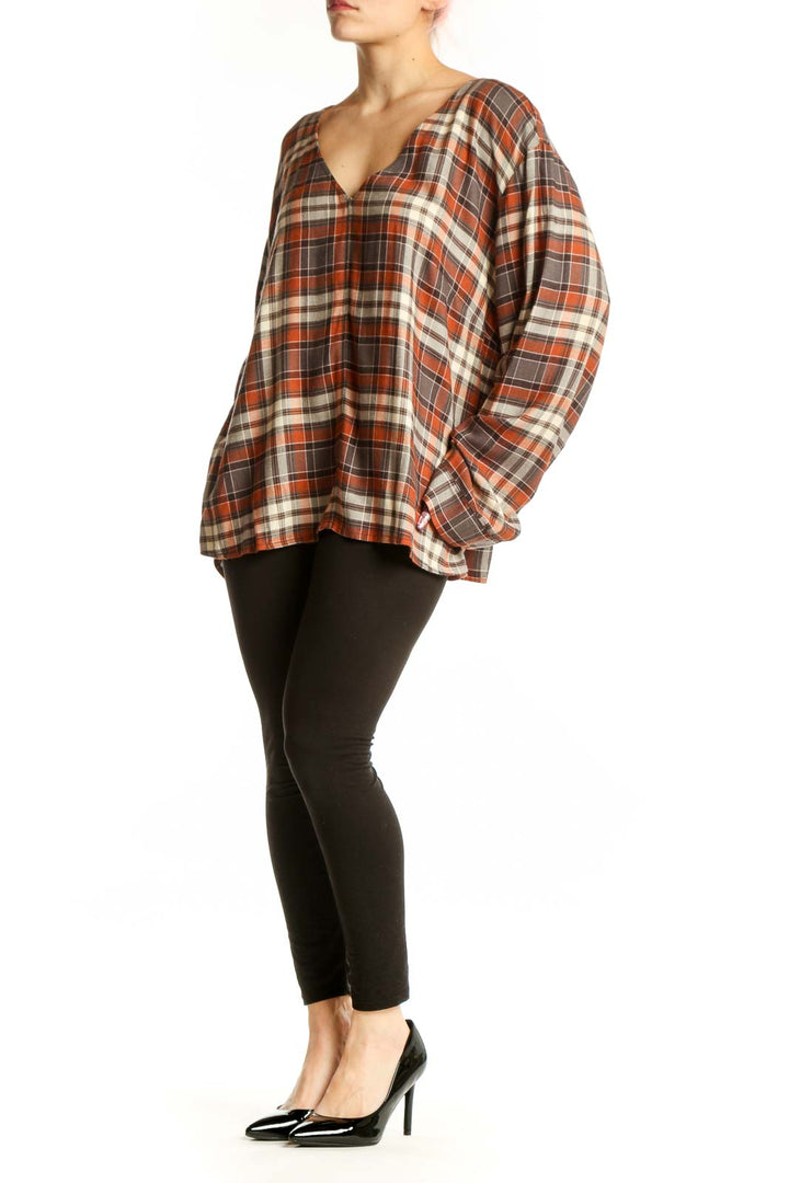 Orange and cream plaid V-neck long sleeve top with oversized fit, front view