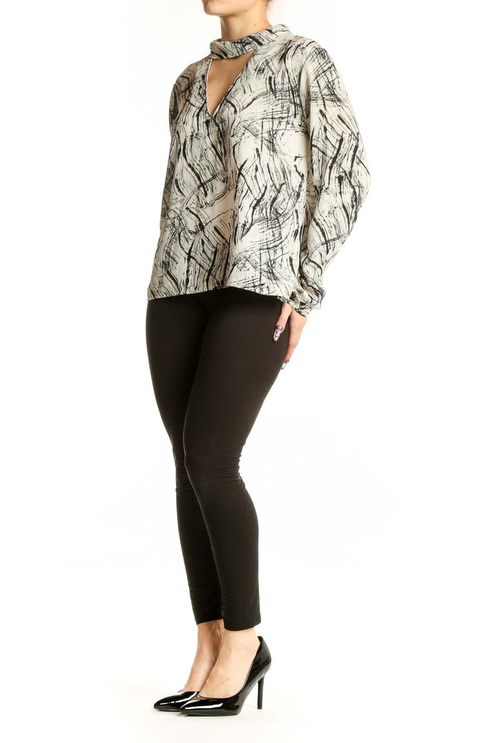 Cream and black abstract print choker blouse with cutout neckline and gathered cuffs, front view