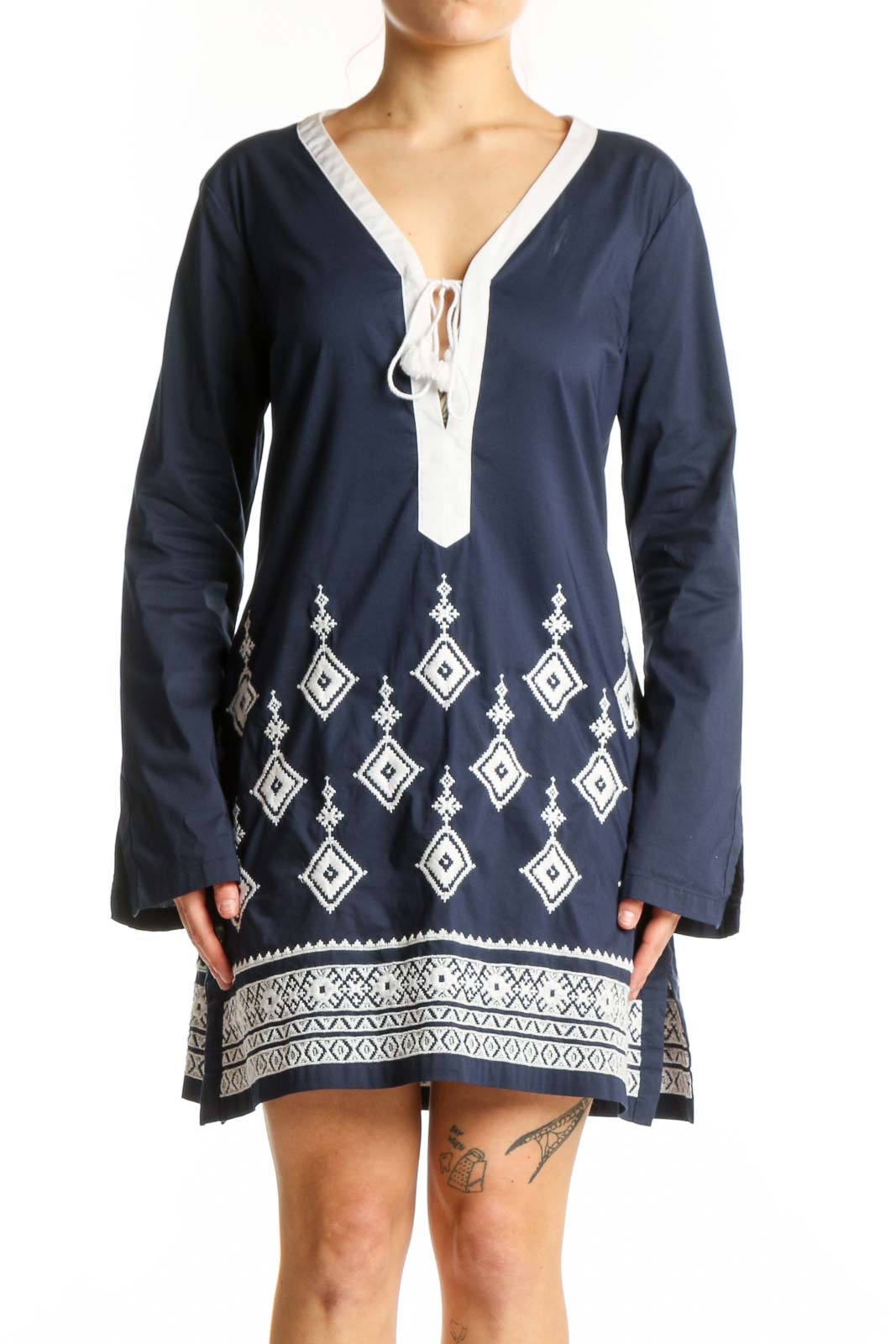 Navy geometric embroidered tunic dress with white tie V-neckline and diamond pattern details