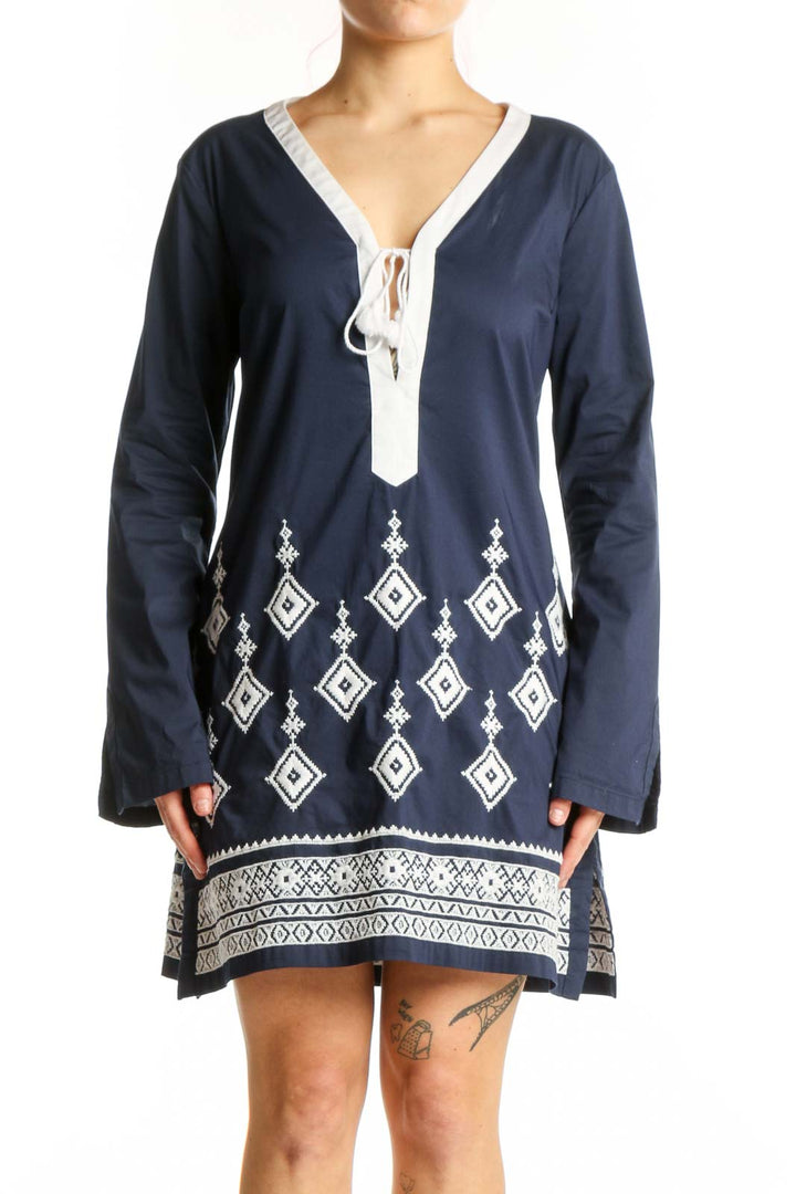 Navy geometric embroidered tunic dress with white tie V-neckline and diamond pattern details